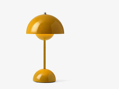 VP9 Flowerpot bordlampe uden ledning i mustard tændt med lys